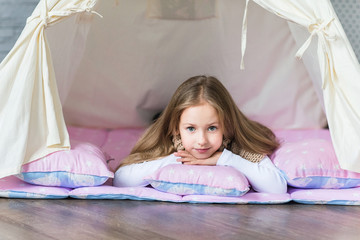 Child playing with a teepee