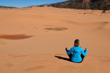 Fototapeta premium Woman meditating in desert. Coral Pink Sand Dunes State Park. Cedar City. Kanab. Utah. United States.
