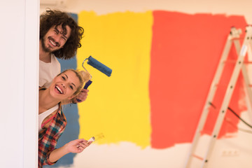 portrait of a couple painting interior wall