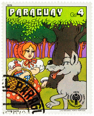 Wolf says to Little Red Riding Hood in the forest - a scene from a fairy tale on postage stamp