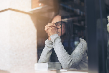 Woman pray while reading the Bible in the library cafe.