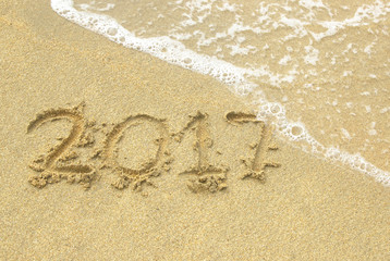 Happy New Year 2017 sand beach by the sea.