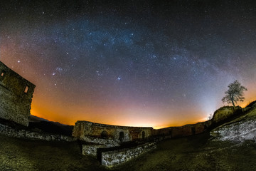 Astro landscape with the Milky Way as seen from the castle ruin Lindelbrunn in the Palatinate Forest in Germany.