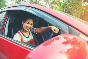 Happy smiling woman in a car red with sunlight