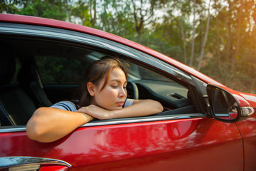 Happy smiling woman in a car red with sunlight