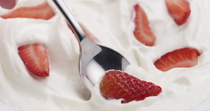 Slow motion of eating strawberries with cream with spoon, 4k 60fps prores footage