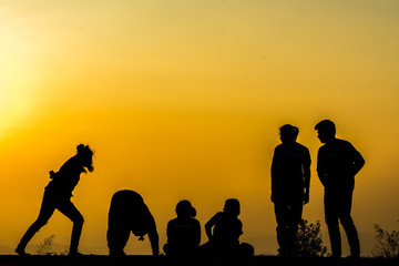 Fototapeta na wymiar silhouette of people group practicing yoga on the beach at sunset