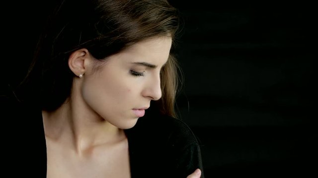 Beautiful woman thinking feeling lonely and sad black background
