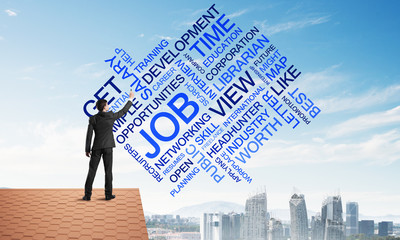 Young businessman standing on house roof and writing leadership skill concept. Mixed media