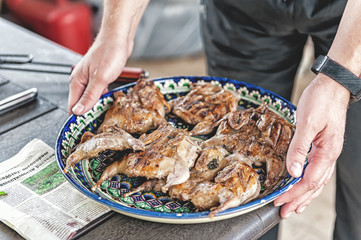 hand feeding a small dish with grilled chicken