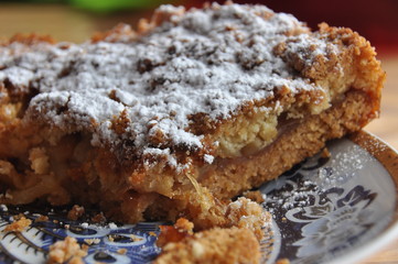 Apple pie dusted with icing sugar on the kitchen table.
