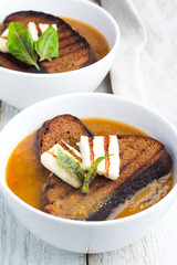 bowl of soup, fried cheese, bread and basil close-up