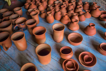 Naklejka na ściany i meble Top view of indian traditional handmade pottery of different sized cups, lamps, and jugs, Chennai, India, Feb 25 2017