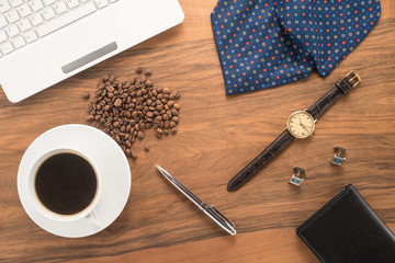 Office table with cup of coffee and men's accessories