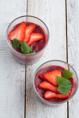 fruit pudding with chia and strawberries in glasses close-up view from above.