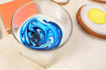 Mixing blue pigment and  white glaze in a glass