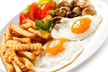Fried eggs, French fries  and vegetables