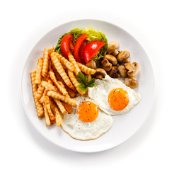 Fried eggs, French fries  and vegetables