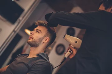 Crédence de cuisine en verre imprimé Salon de coiffure Handsome man at the hairdresser getting a new haircut