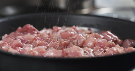 grinding pepper on pork meat frying on pan cooking pilaf, 4k photo