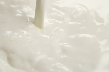 pouring milk into bowl from above, closeup photo