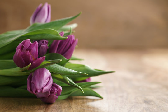 Fototapeta bouquet of purple tulips on wood table with copy space, shallow focus