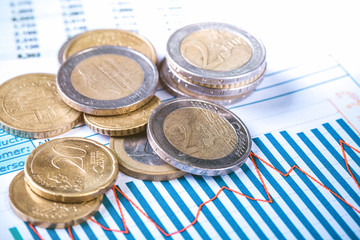 Euro coins on fluctuating graph. Selective focus