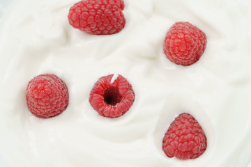 macro photo of organic yogurt with fresh raspberries, food background