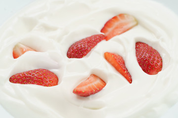 macro photo of organic yogurt with fresh sliced strawberries, food background
