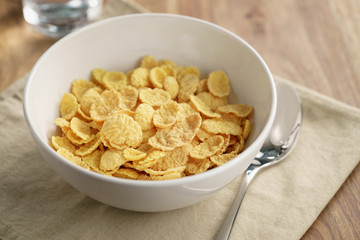 dry corn flakes for breakfast in bowl on table, breakfast preparation
