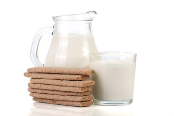 jug and glass of milk with stack of grain crispbreads isolated on white background