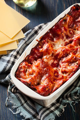 Hot tasty lasagna with spinach in ceramic casserole dish