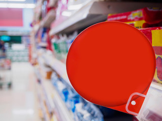 red discount sign display on supermarket shelves