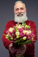 Focus on a bouquet of fresh tulips given by bearded gentleman