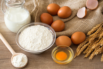 top view eggs, flour and baking ingredients on wooden table .