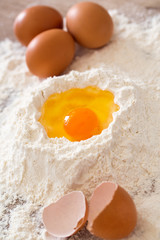 Baking ingredients -breaking egg and flour.