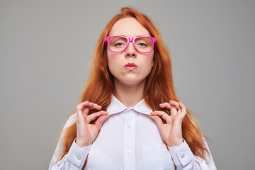 Confident readhead teen adjusting blouse collar