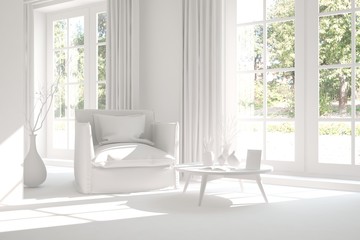 White room with armchair and green landscape in window. Scandinavian interior design