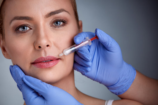Woman having injection in lips,  beauty treatment