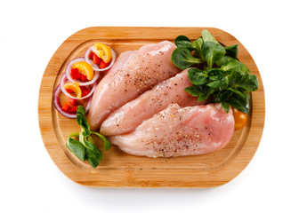 Raw chicken breasts on cutting board 