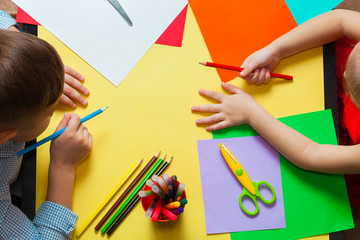 Little boy and girl doing crafts. Children ready to draw on colored paper.