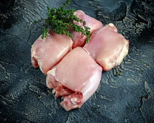 Raw Free range Boneless skinless chicken thighs with thime on stone table