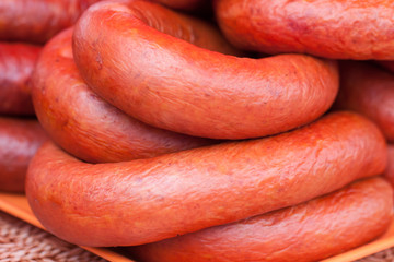 Ring smoked sausage on the market as a background. Selective focus