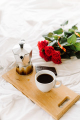 A cup of coffee, coffee on the wooden Boards, a bouquet of red roses on a white background