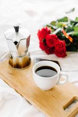 A cup of coffee, coffee on the wooden Boards, a bouquet of red roses on a white background