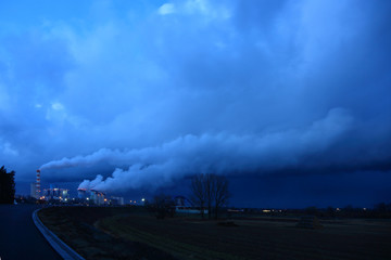 Dymiące kominy elektrowni Opole wieczorem po zachodzie słońca. - obrazy, fototapety, plakaty