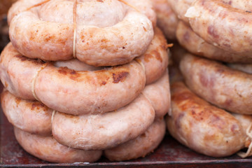 Roasted spiral pork sausages as a background. Selective focus