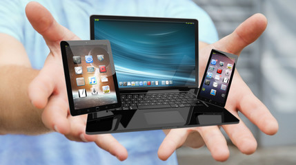 Businessman holding laptop phone and tablet in his hand 3D rendering