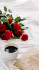 cup of coffee and a bouquet of red roses, envelope