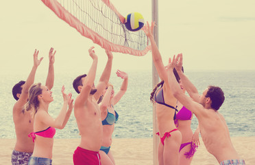 Active adults playing beachvolley